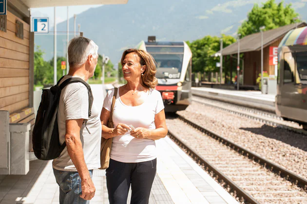 Un uomo e una donna aspettano l'arrivo del treno. che entra in stazione.