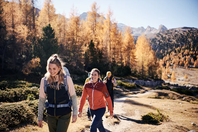 Tre persone passeggiano in montagna in autunno