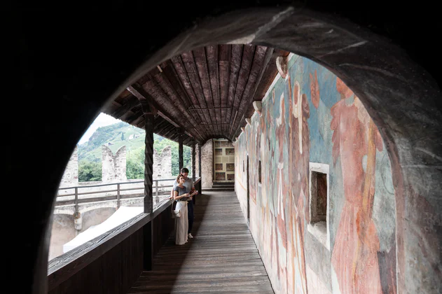 Un donna su una passarella intenta ad ammirare gli affreschi di Castel Roncolo vicino a Bolzano