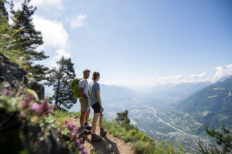 Due persone si godono il vasto panorama della Val Venosta da un'altura