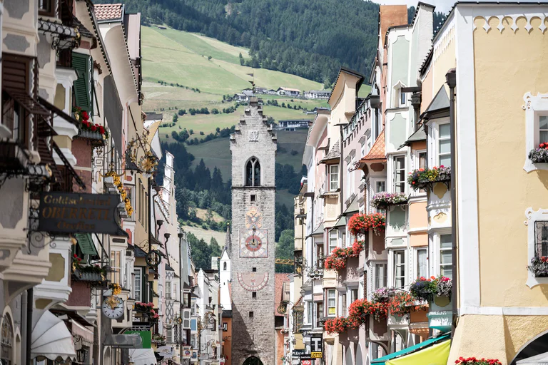 The main Neustadt shopping street in Sterzing with a view of the Zwölferturm tower.