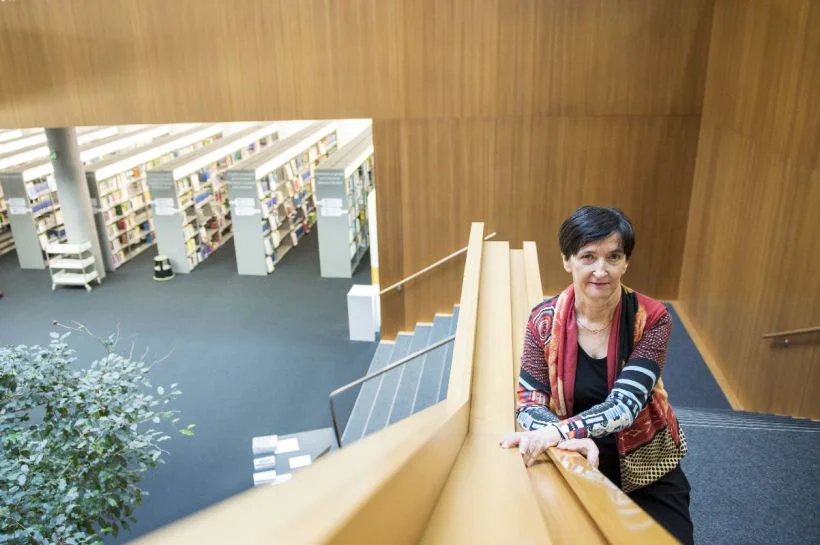 La linguista Rita Franceschini è in piedi sulle scale della Biblioteca Universitaria di Bolzano.