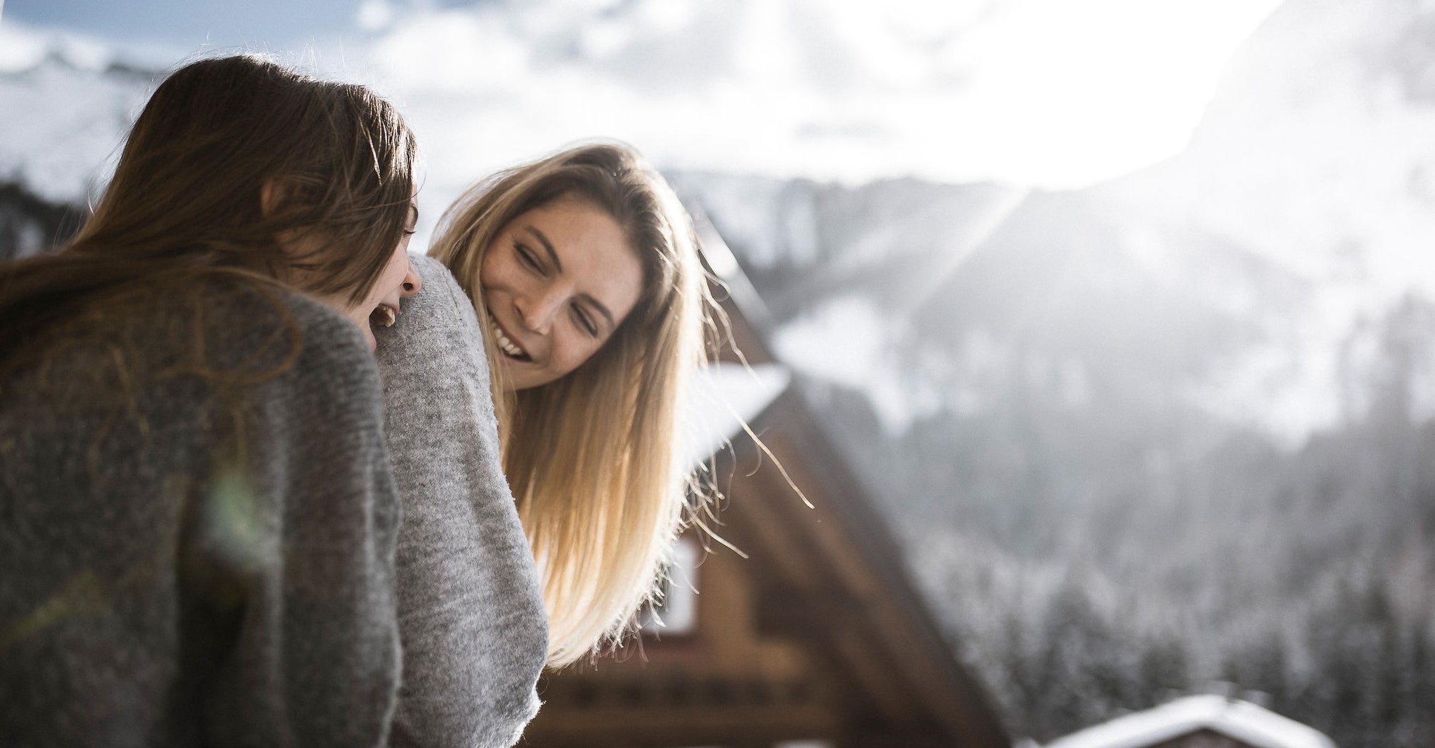 Mutter mit Tochter vor einer Almhütte im Winter im Ahrntal