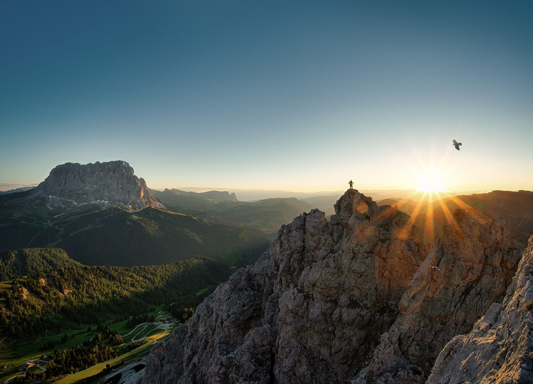 Eine Person steht auf der Cir-Spitze bei Wolkenstein im Herbst