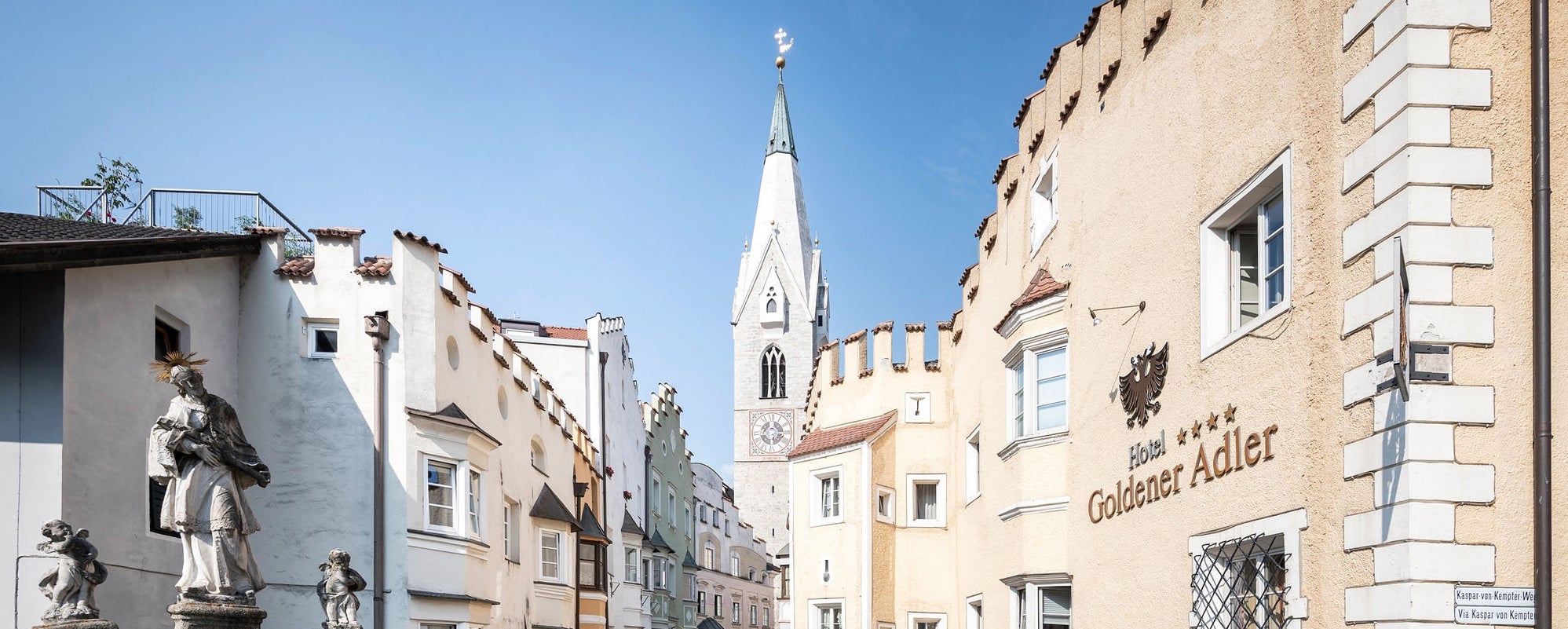 Der Weiße Turm von Brixen erstrahlt über die historische Adlerbrückengasse