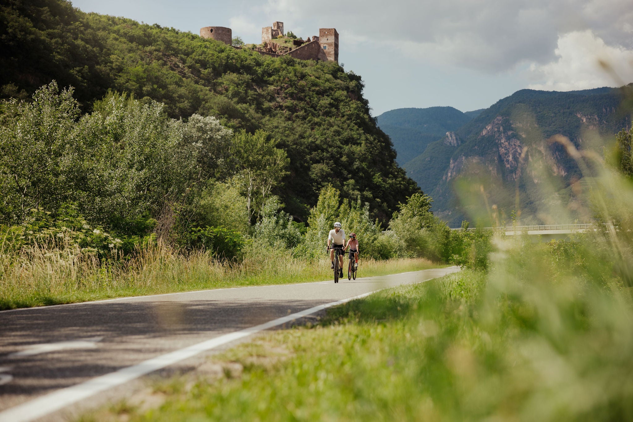 Zwei Radfahrer auf dem Talradweg am Fuße von Schloss Sigmundskron und MMM Firmian von Reinhold Messner