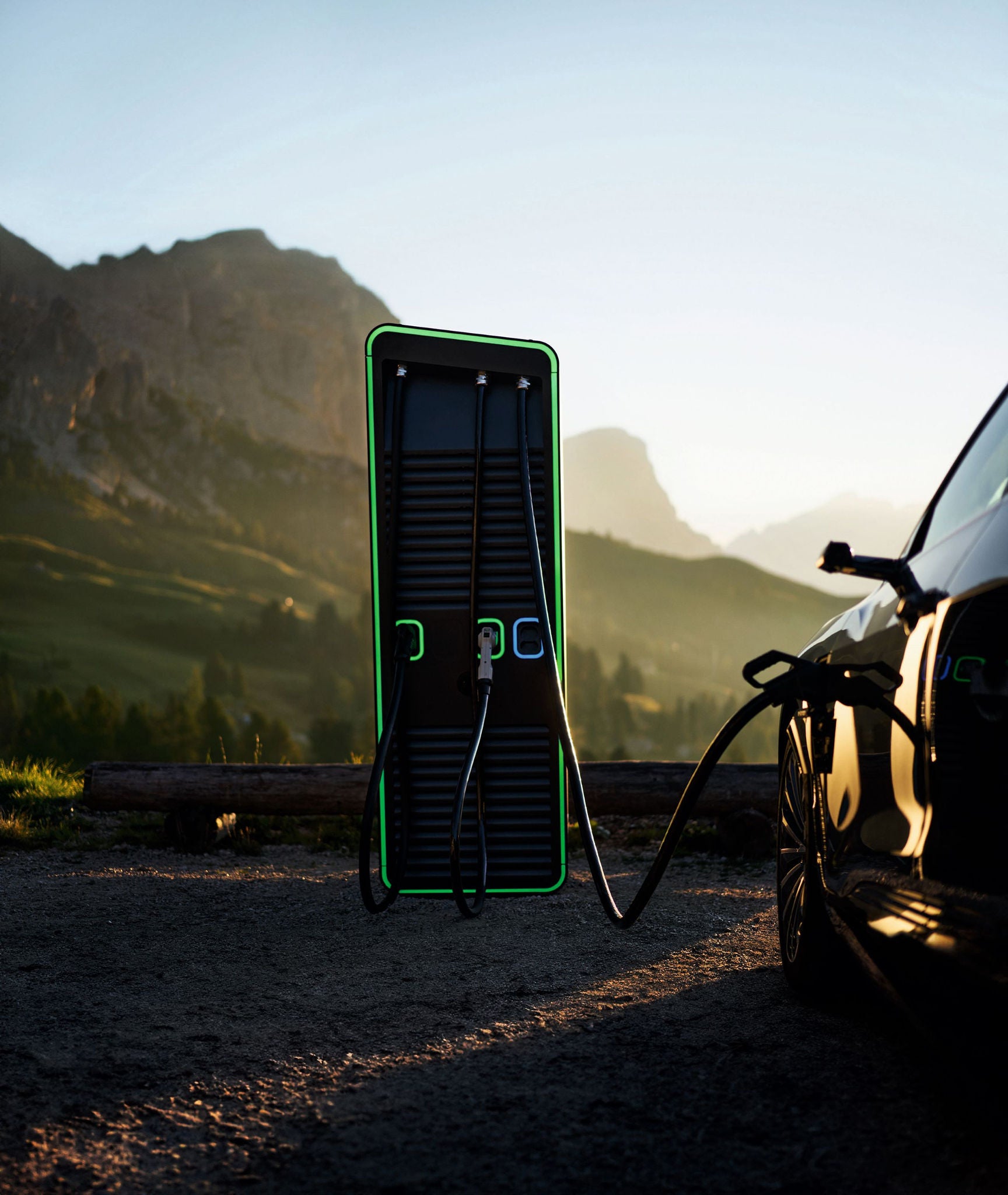 Eine moderne E-Ladestation im Gebrauch, daneben ein Auto