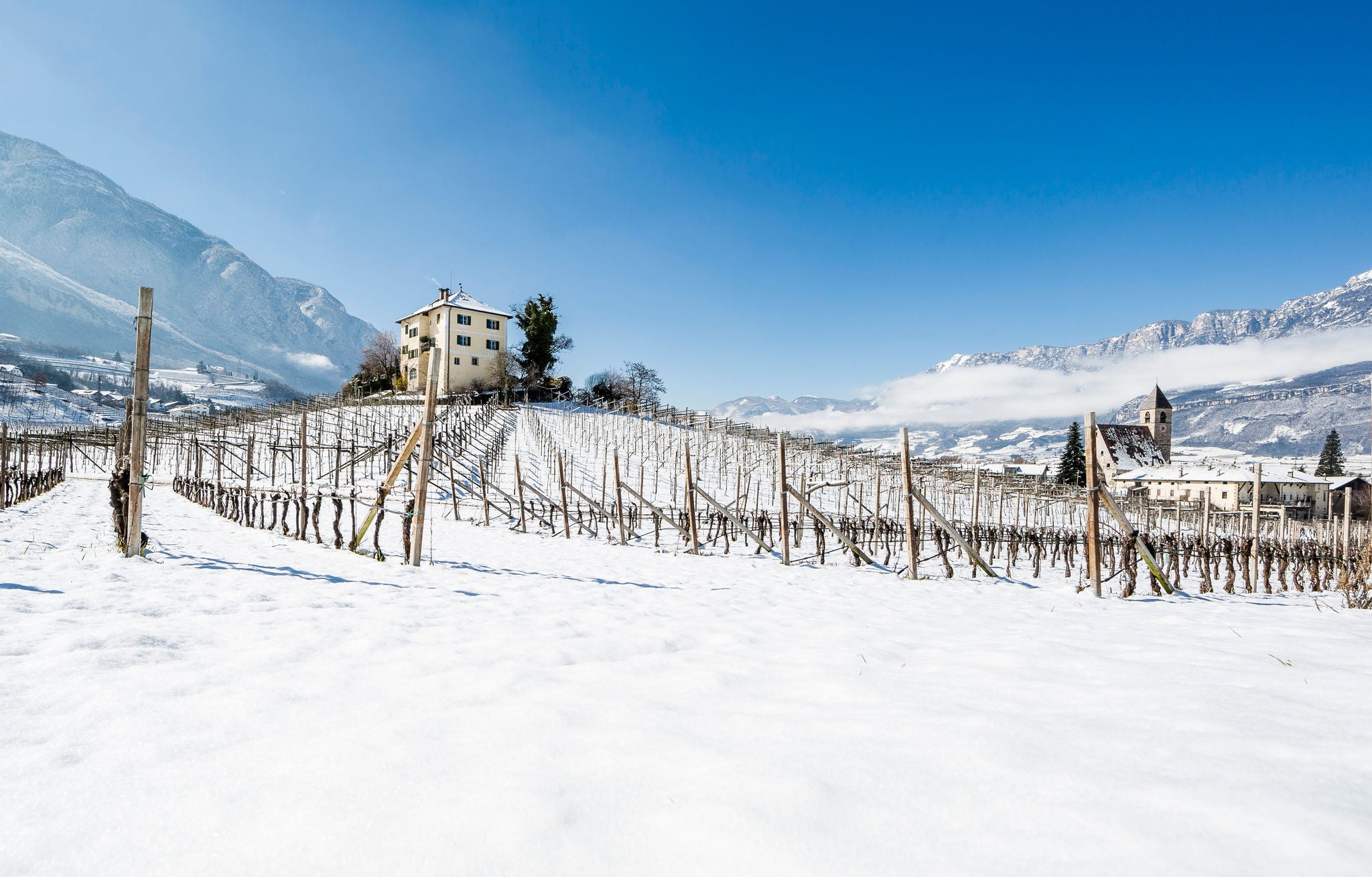 Ein Ansitz bei verschneiten Weinbergen in Kurtatsch