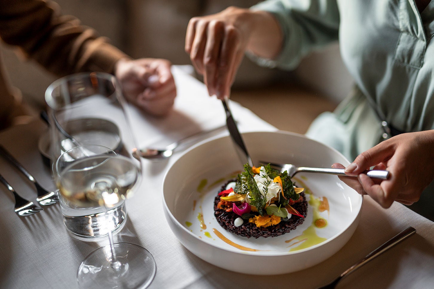 Ein Teller Risotto aus schwarzem Reis mit Blüten