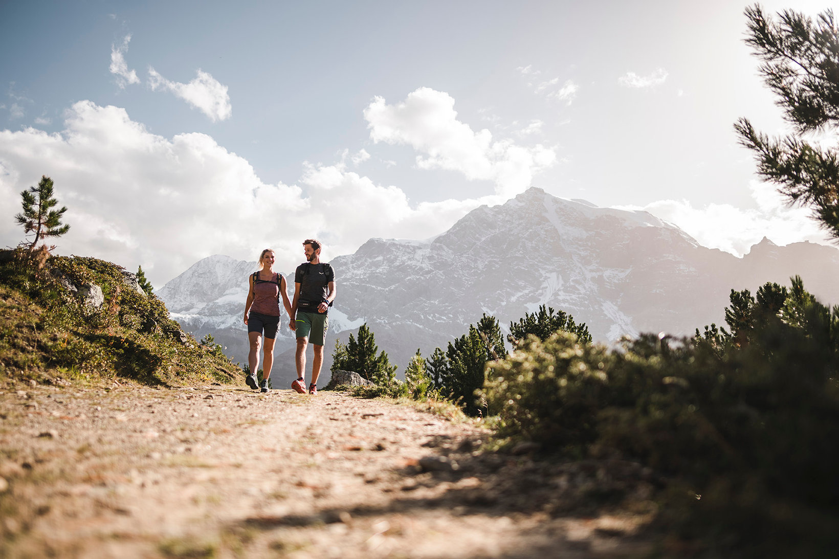 A couple hikes on a path in the Stilfser Joch National Park with a beautiful view over majestic mountains