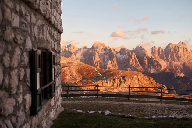 Panoramic view from the green fields of the Seiser Alm high plateau over the Dolomites with a traditional hut in front