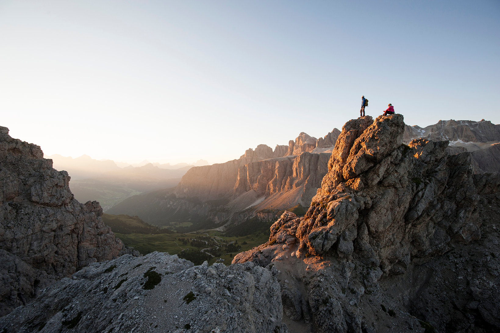 twee personen rusten uit op de top van een berg in de Dolomieten.