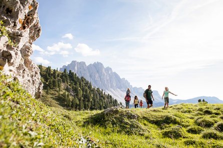 Mężczyzna stoi na szczycie na tle pasma górskiego w Dolomitach, w regionie Villnösstal