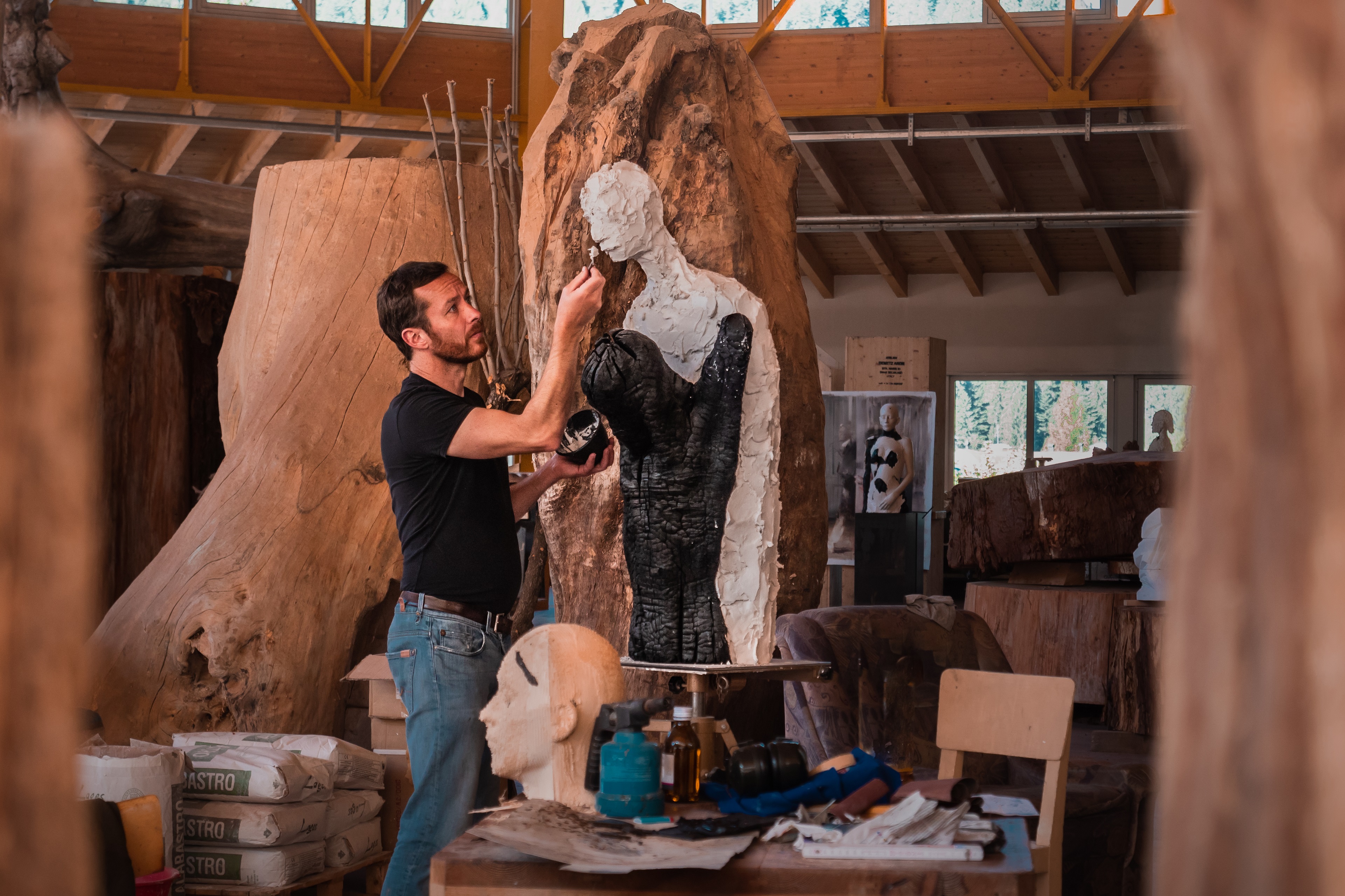 Le sculpteur Aron Demetz travaille sur une œuvre d’art dans son atelier.